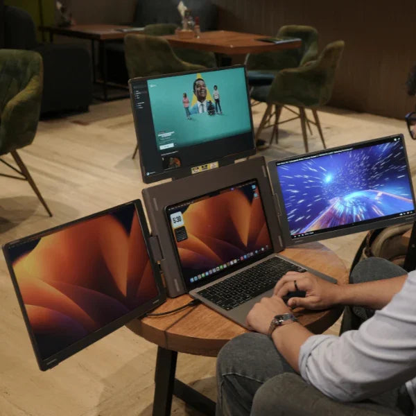 Person using a laptop with four screens