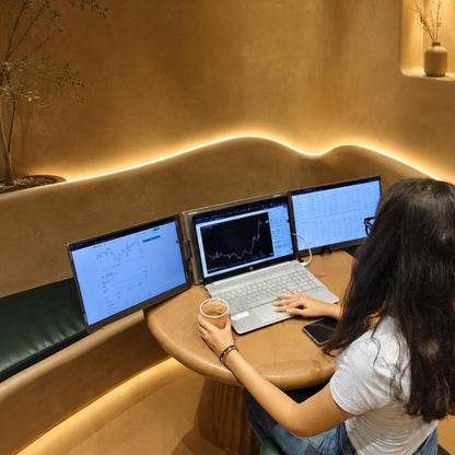 Woman using RIITEK 16 inch tri portable monitor for multitasking at a lounge workspace